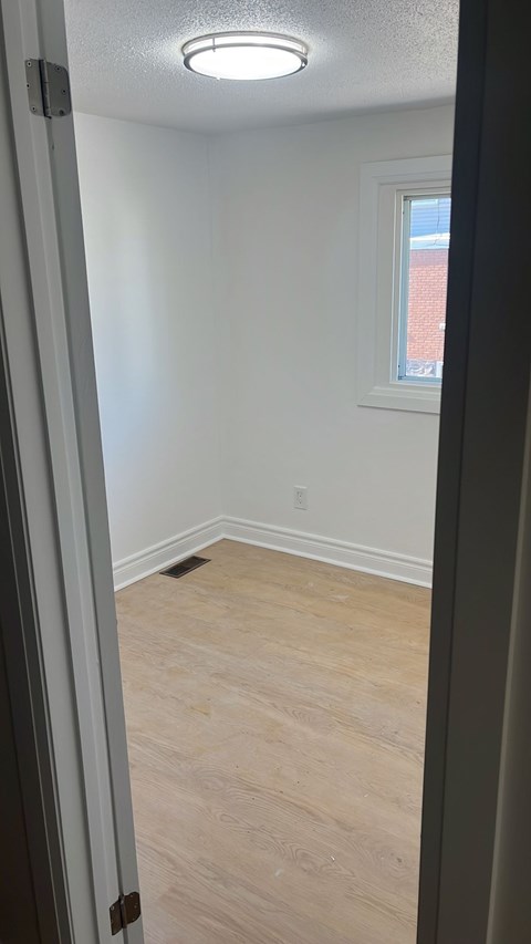 A room with a window and a light on the ceiling.