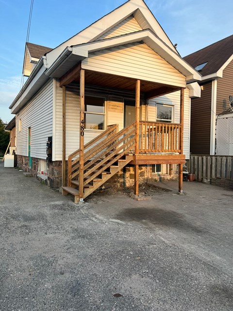 A house with a wooden deck and a garage door.