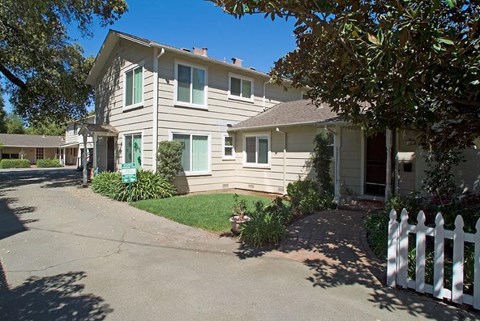 A house with a white picket fence in front.