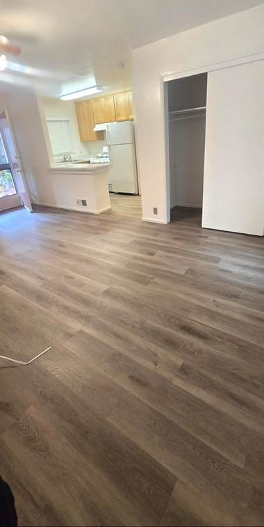 A room with wooden flooring and white walls.