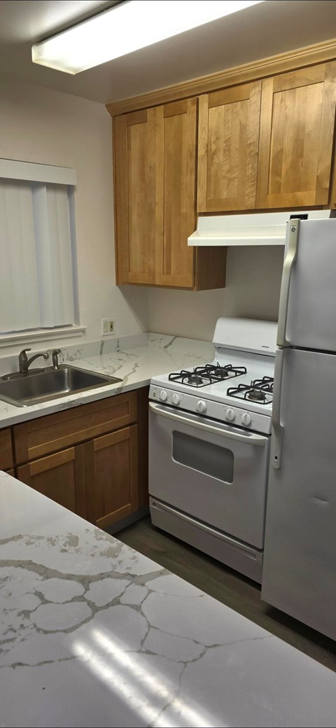 A kitchen with wooden cabinets and a white refrigerator.