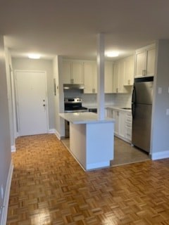 A kitchen with a refrigerator, stove, and oven.