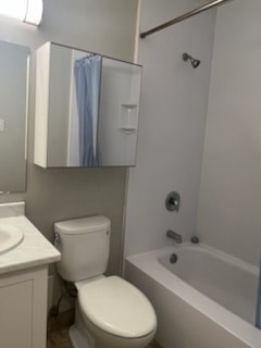 A white toilet sits next to a bathtub in a bathroom.