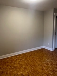 A room with a wooden floor and a white wall.