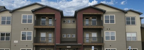 Apartment building with balconies and multiple windows.