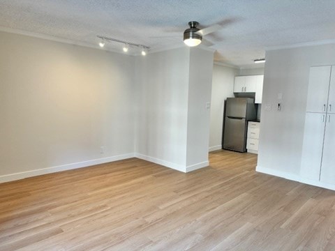 A room with a ceiling fan and wooden flooring.