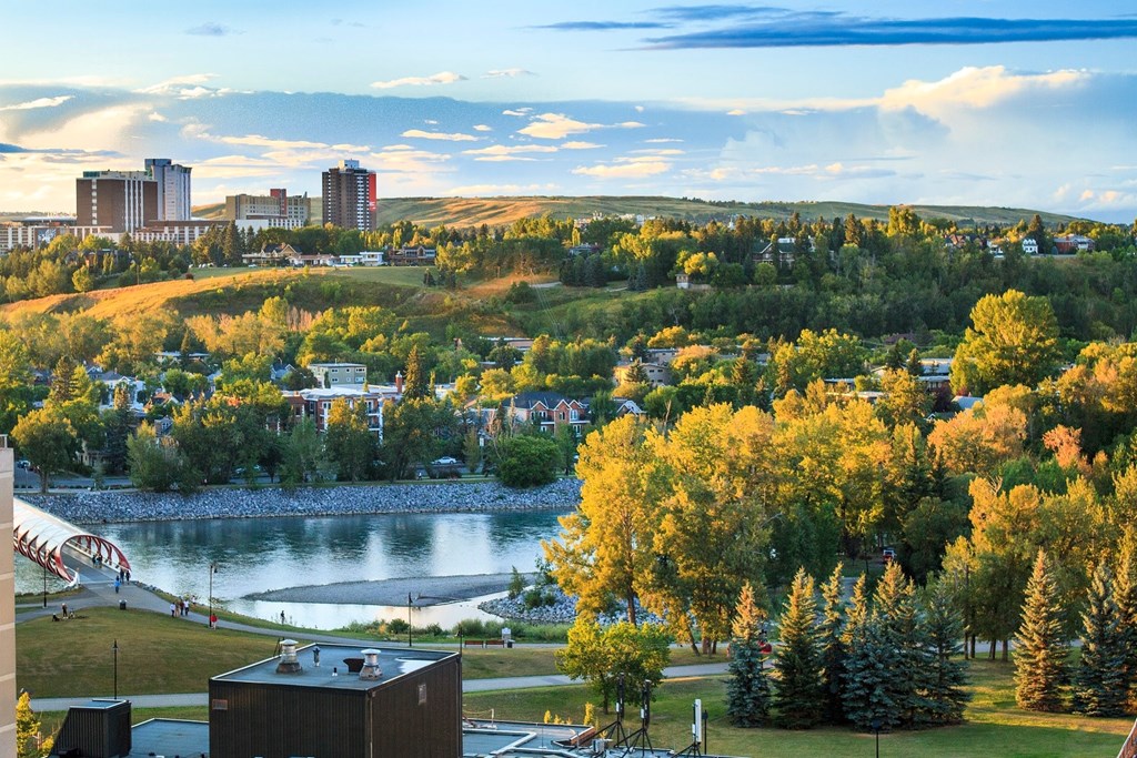 A cityscape with a river and autumn trees.