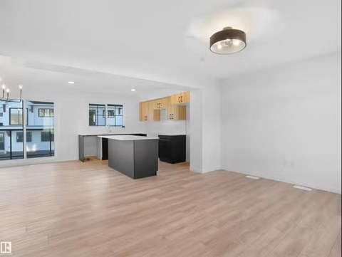 A spacious room with a black counter and wooden flooring.