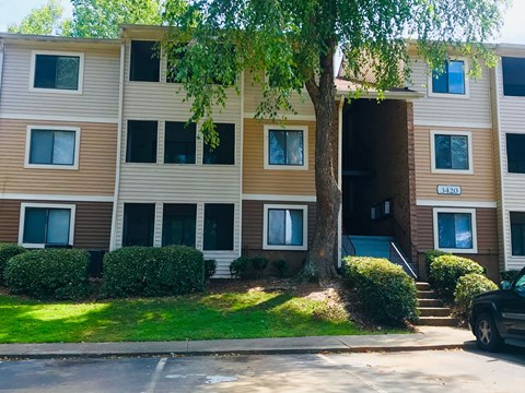 A brown and beige apartment building with the number 3420 on the front door.