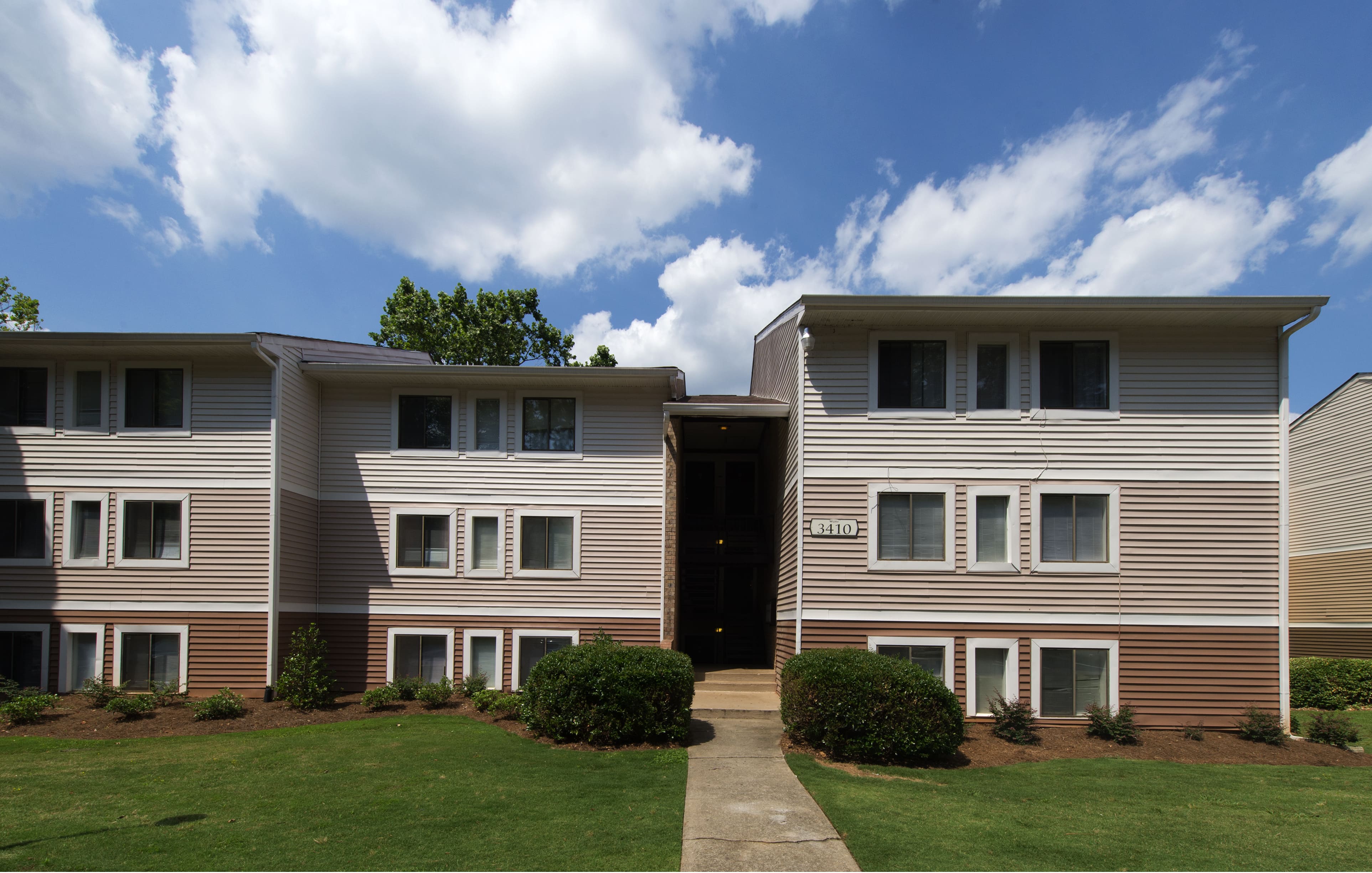 A building with a brown and beige exterior and a black door.