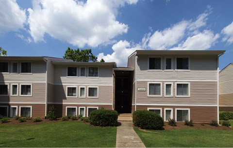 A building with a brown and beige exterior and a black door.