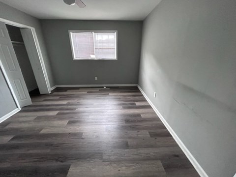 A room with wooden flooring and a window.