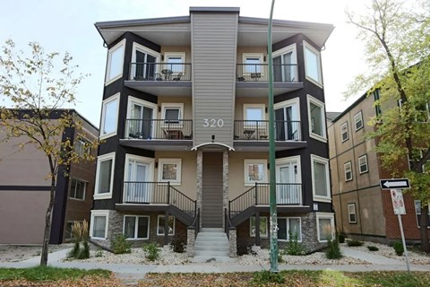 Apartment building number 320 with a tree in front.
