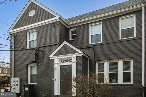 A grey house with a white door and windows.