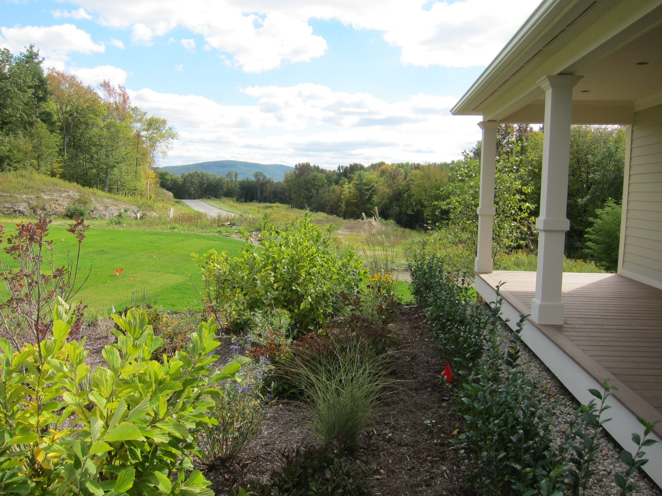 A view of a green landscape from a porch.