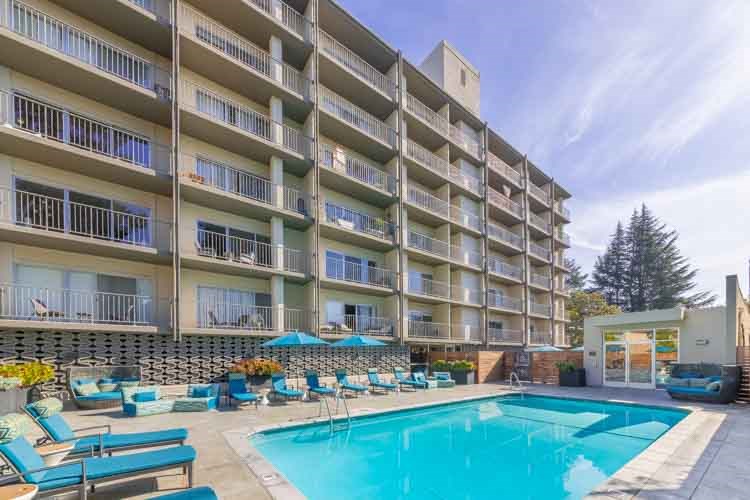 a large swimming pool in front of a hotel