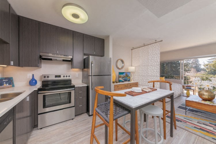 a kitchen with stainless steel appliances and a table with chairs