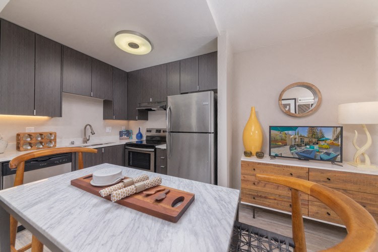 a kitchen and dining room with stainless steel appliances and a table