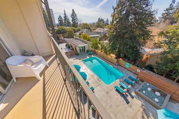 a view of the pool from the balcony of a house