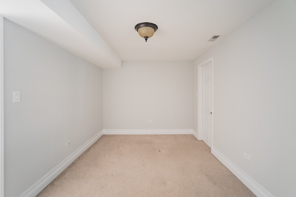 a empty room with white walls and a ceiling light
