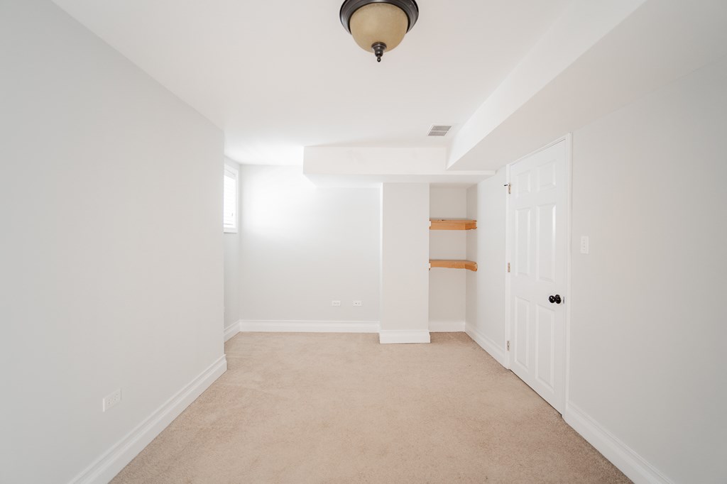 a room with white walls and a white door and a carpet