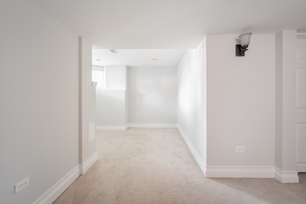an empty living room with white walls and a white carpet