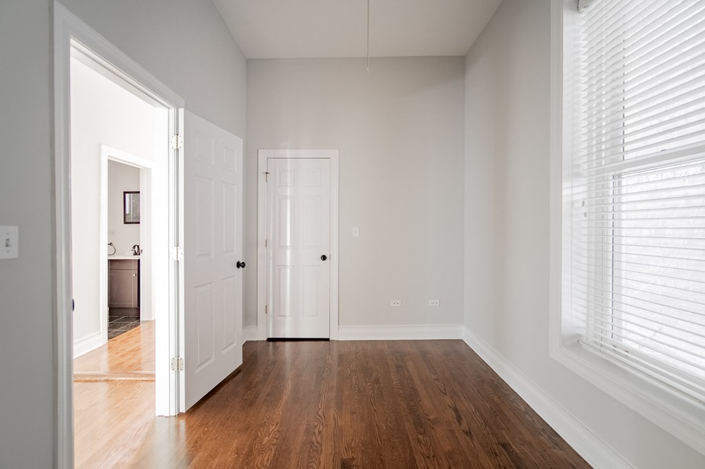 an empty living room with wood floors and white walls
