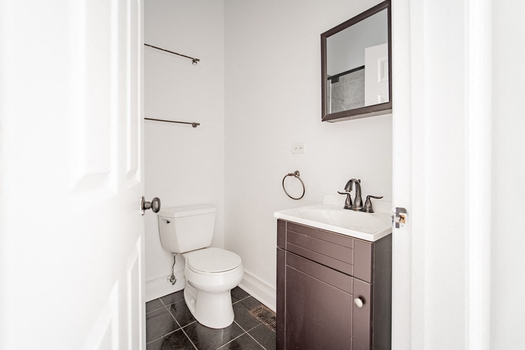 a bathroom with a toilet and a sink and a mirror