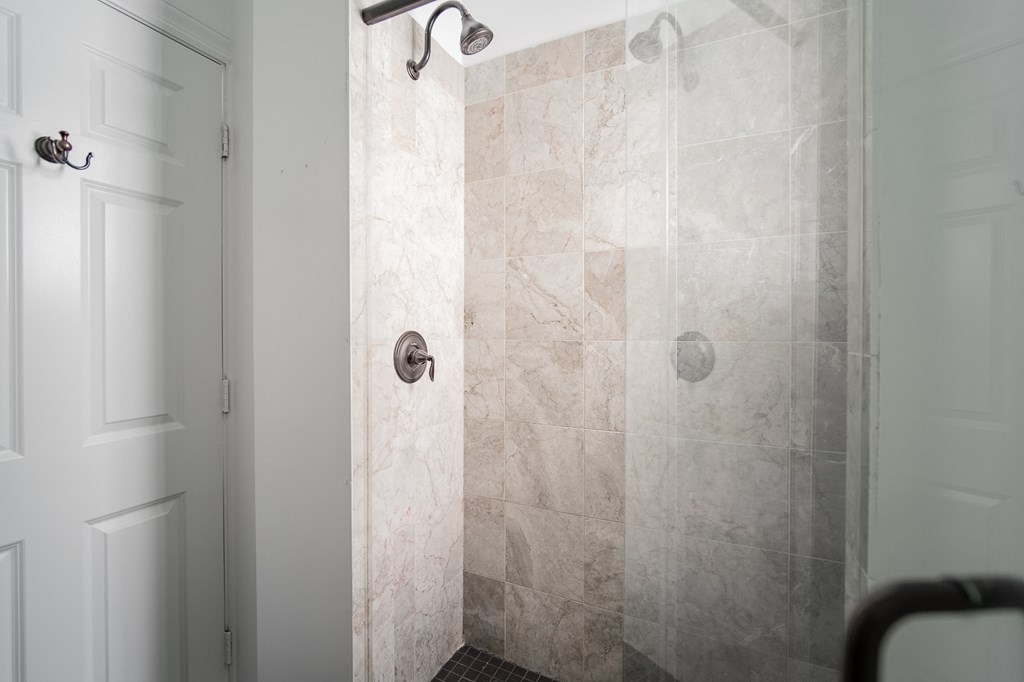a bathroom with a shower and a white door