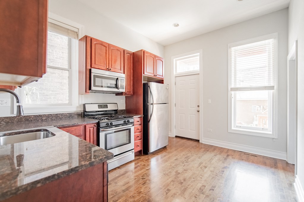 an empty kitchen with wooden cabinets and stainless steel appliances