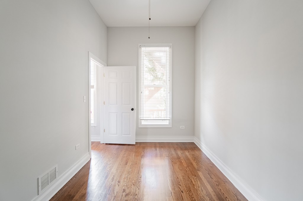 an empty living room with white walls and wood floors