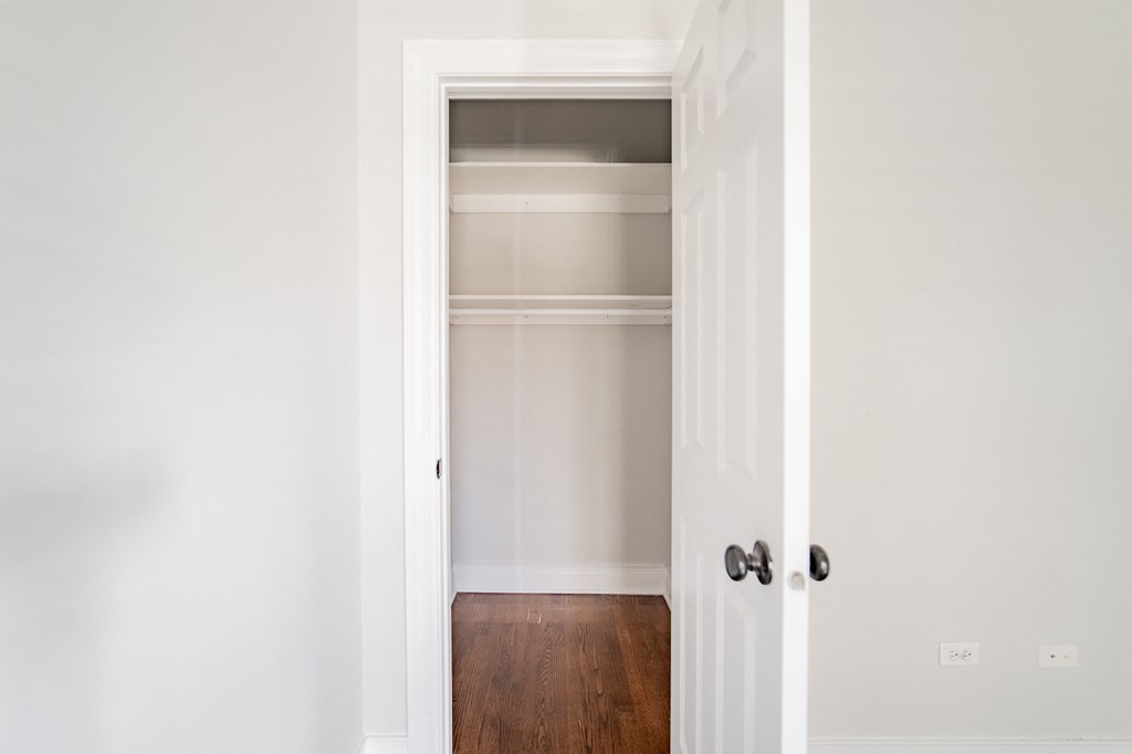 an empty closet in a home with a door open
