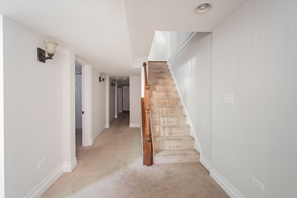 a staircase in a home with white walls and carpet