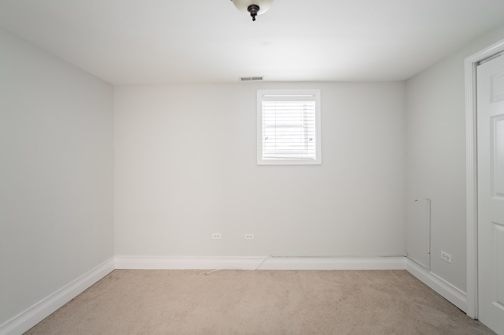 an empty room with white walls and a window