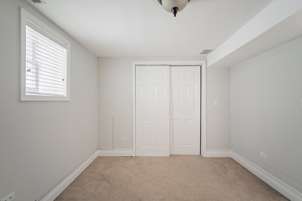an empty bedroom with a closet and a window