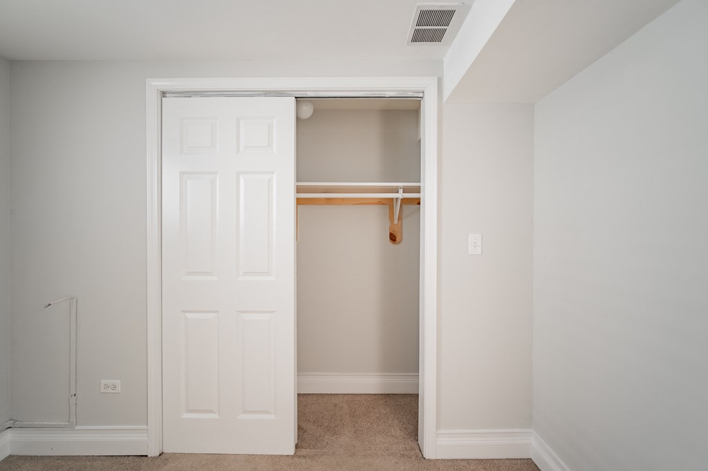 an empty closet in a bedroom with a white door