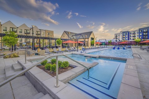 A swimming pool surrounded by a concrete patio and steps.