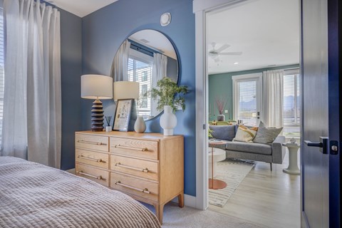 A bedroom with a bed, dresser, and mirror.