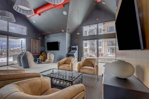 A modern living room with a glass coffee table and leather chairs.
