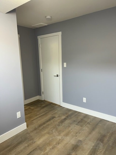 A room with a white door and grey walls.
