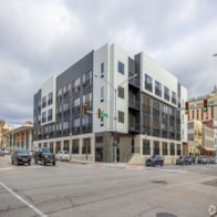 A modern building with a black and white facade is situated on a street corner.