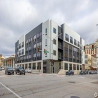 A modern building with a black and white facade is situated on a street corner.