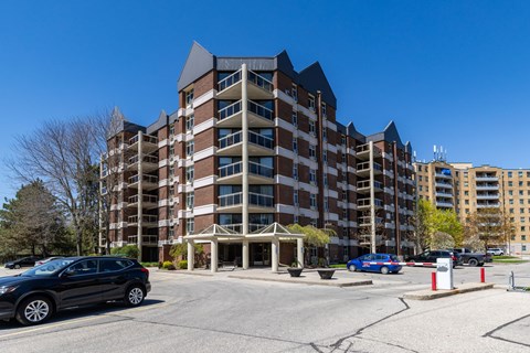 A large multi-story apartment building with a parking lot in front.