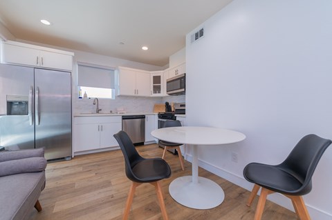 A modern kitchen with a table and chairs.