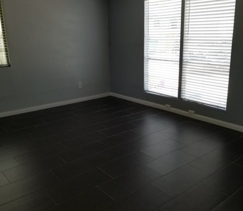 A room with a window and a tiled floor.