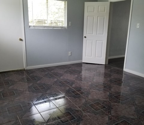 A room with a tiled floor and a white door.