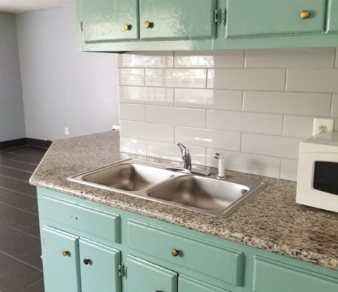 A kitchen with a sink and a microwave.