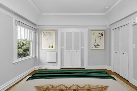 A white room with a green rug and a brown bench.