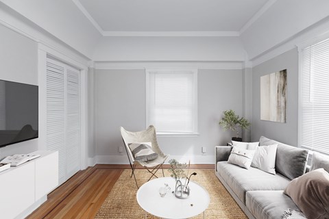 A living room with a white sofa, a white coffee table, and a white chair.