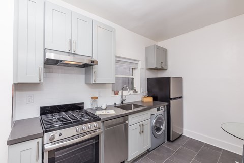 A kitchen with a black stove top oven and a black refrigerator.